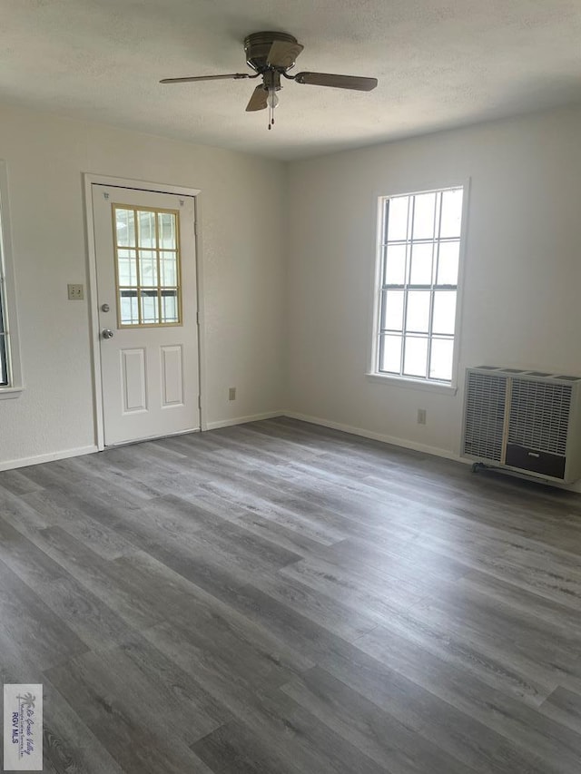 interior space with a textured ceiling, ceiling fan, and dark wood-type flooring