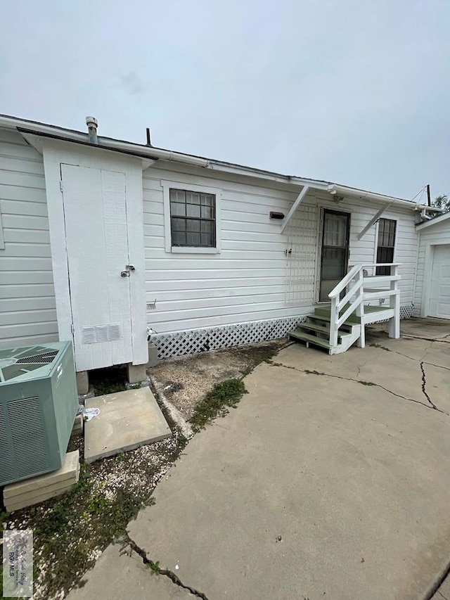 back of house with an outdoor structure and central air condition unit