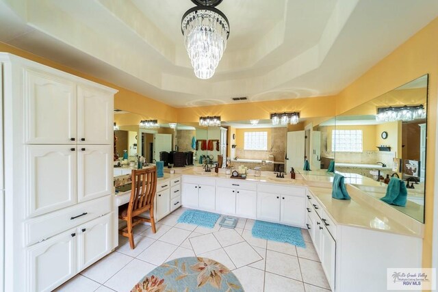 full bath with visible vents, tile patterned floors, a tray ceiling, a chandelier, and a sink