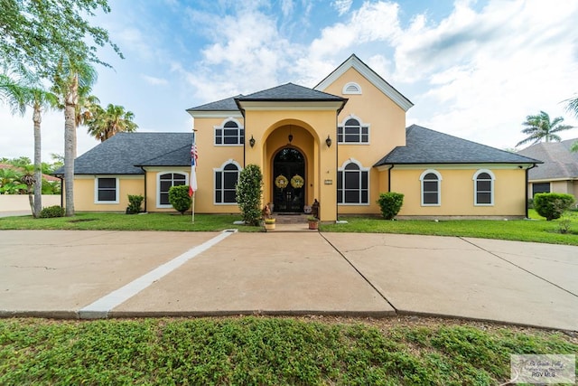 mediterranean / spanish-style home with stucco siding and a front yard