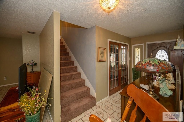 foyer featuring stairway, french doors, visible vents, and baseboards