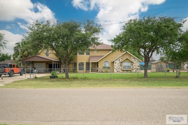 view of front facade with a front lawn, a carport, and a fenced front yard