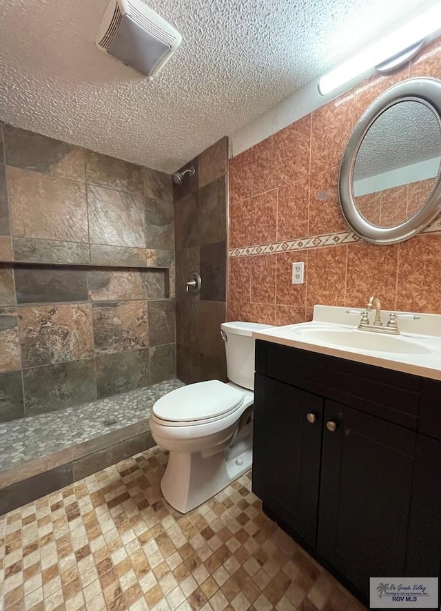 full bath featuring visible vents, toilet, a textured ceiling, tile walls, and tiled shower