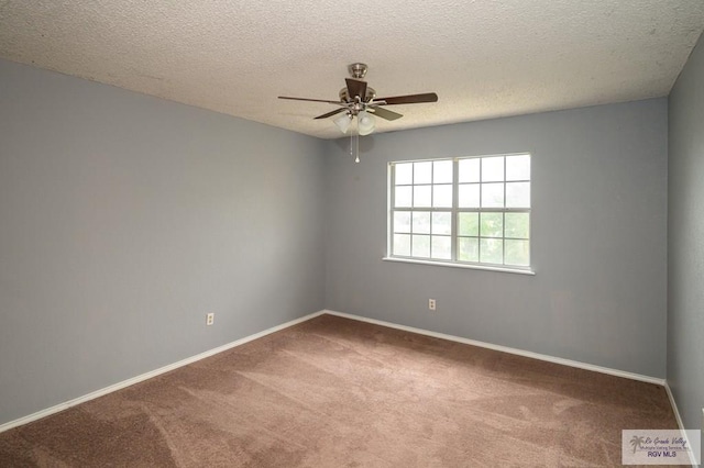 carpeted spare room featuring baseboards, a textured ceiling, and a ceiling fan