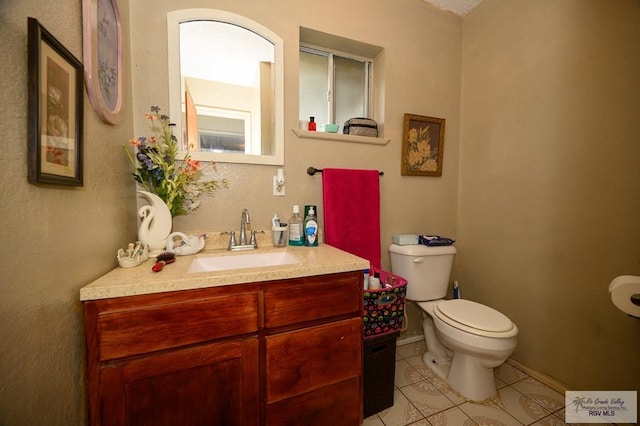 bathroom featuring tile patterned floors, baseboards, toilet, and vanity