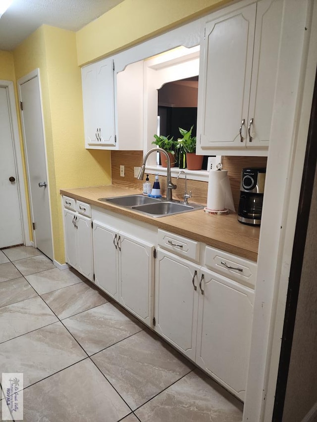 480 Madrid Ct, San Benito, TX 78586 - kitchen with a sink, white cabinets, and light tile patterned flooring