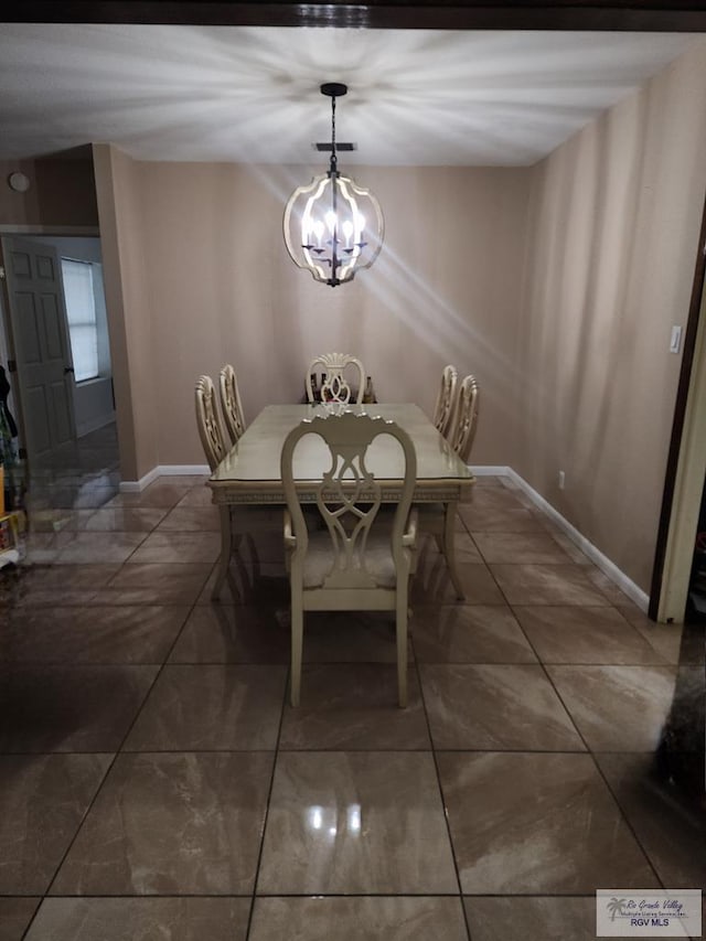 480 Madrid Ct, San Benito, TX 78586 - tiled dining space with baseboards and a chandelier