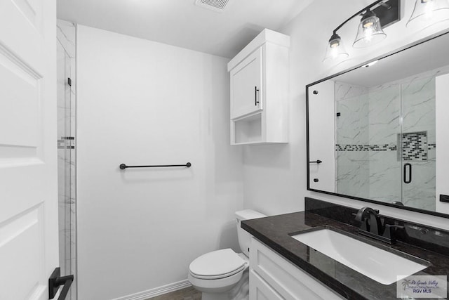 bathroom featuring vanity, an enclosed shower, and toilet