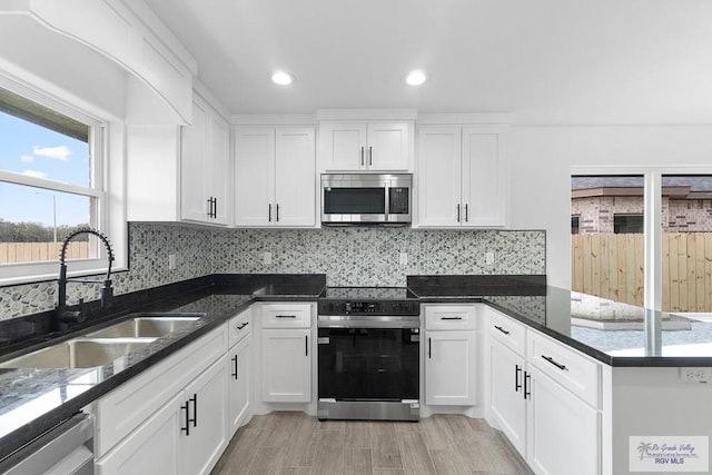 kitchen featuring white cabinets, sink, light wood-type flooring, and stainless steel appliances