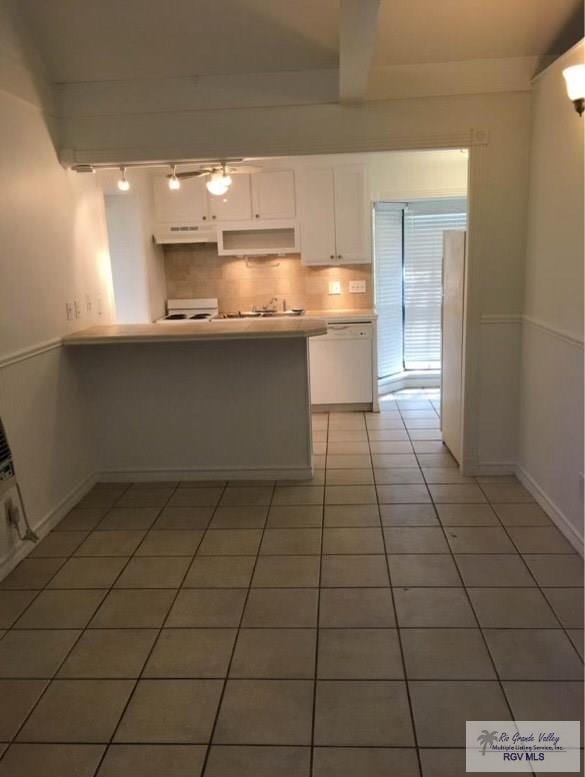 kitchen with white cabinetry, dishwasher, tile patterned floors, kitchen peninsula, and extractor fan