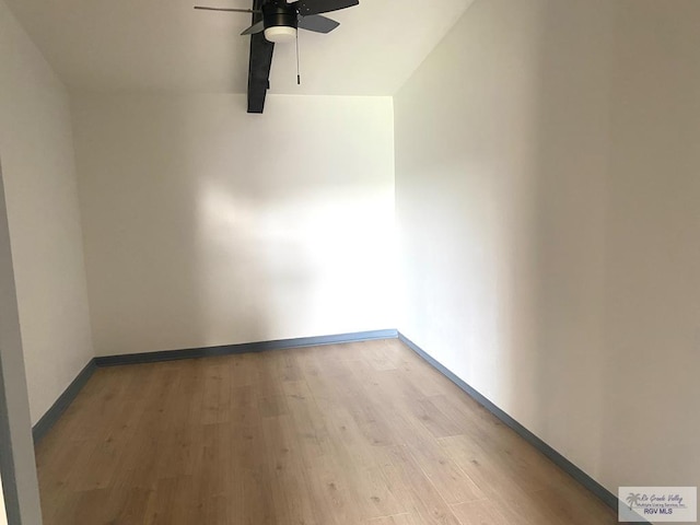 spare room featuring light wood-style floors, baseboards, and ceiling fan