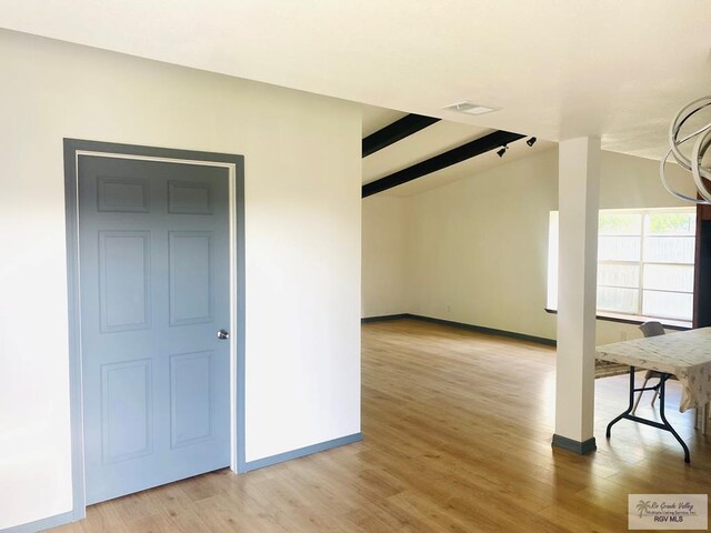 additional living space with beamed ceiling, an inviting chandelier, light wood-style flooring, visible vents, and baseboards