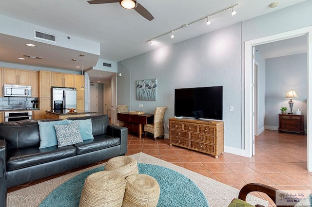 living room featuring light tile patterned floors, rail lighting, and ceiling fan