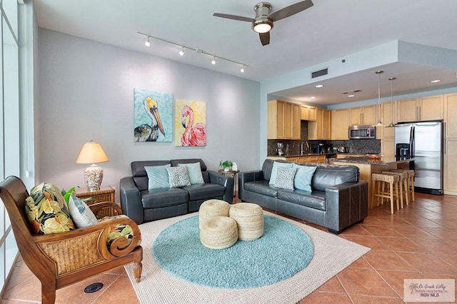 living room with light tile patterned floors, ceiling fan, and sink