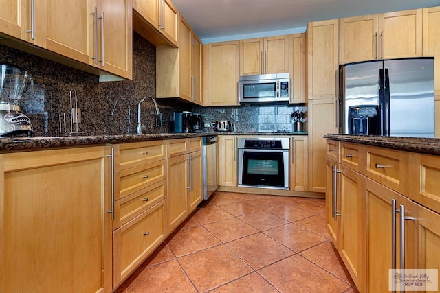 310A Padre Blvd Unit 803, South Padre Island, TX 78597 - kitchen featuring stainless steel appliances, decorative backsplash, dark stone countertops, and light brown cabinets