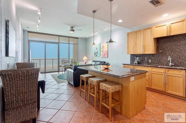310A Padre Blvd Unit 803, South Padre Island, TX 78597 - kitchen featuring rail lighting, light brown cabinets, a center island, open floor plan, and a wall of windows