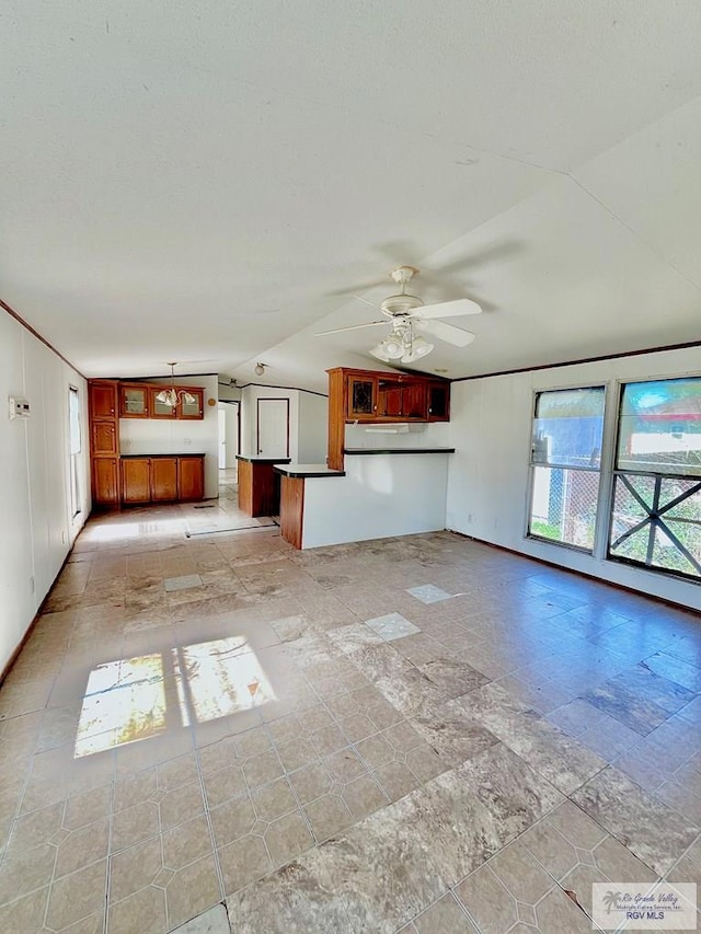 unfurnished living room with ceiling fan, stone finish flooring, and lofted ceiling