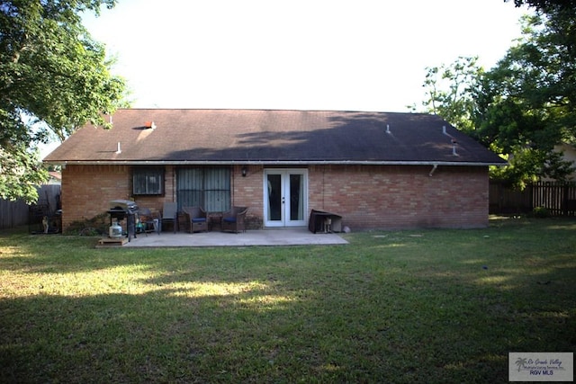 back of house featuring a lawn, a patio, and french doors