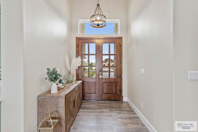 doorway featuring french doors, wood finished floors, and baseboards