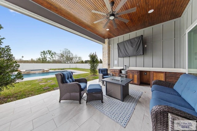 view of patio featuring ceiling fan, an outdoor living space with a fire pit, a fenced backyard, and a pool with connected hot tub