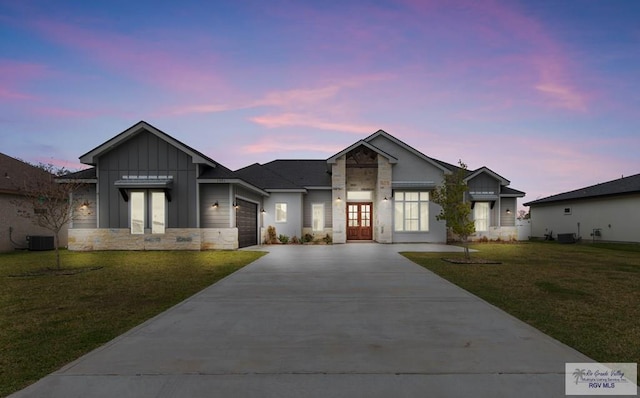 view of front of house with board and batten siding, concrete driveway, a lawn, and a garage