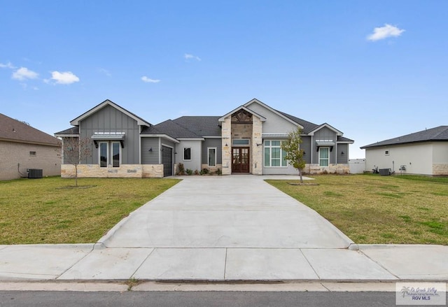 view of front of property featuring board and batten siding, a front yard, and stone siding