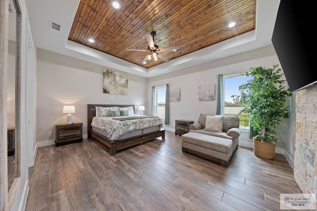 bedroom with visible vents, wood finished floors, a raised ceiling, and wood ceiling