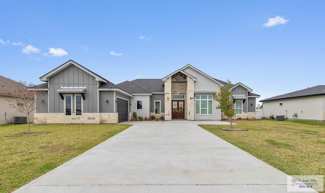 view of front of house featuring a garage, stone siding, french doors, a front lawn, and board and batten siding