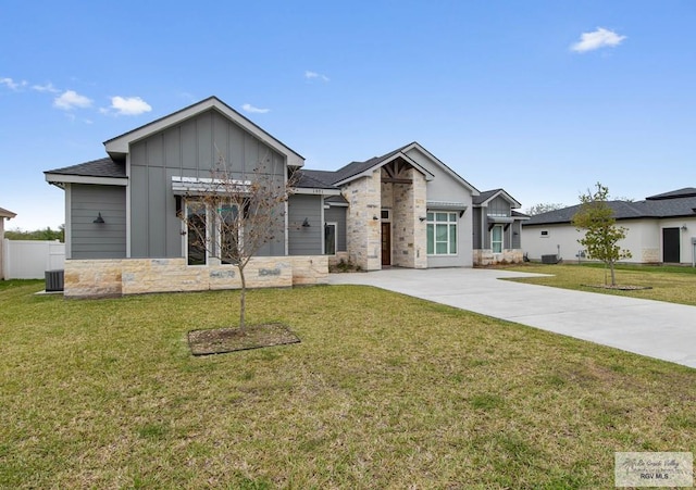 view of front facade featuring board and batten siding, a front yard, stone siding, and concrete driveway