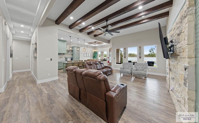 living area with light wood-type flooring, ceiling fan, baseboards, and beam ceiling