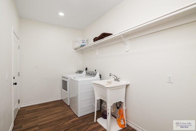 washroom with dark wood-type flooring and washing machine and clothes dryer