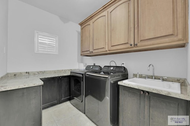 clothes washing area featuring cabinets, independent washer and dryer, light tile patterned floors, and sink