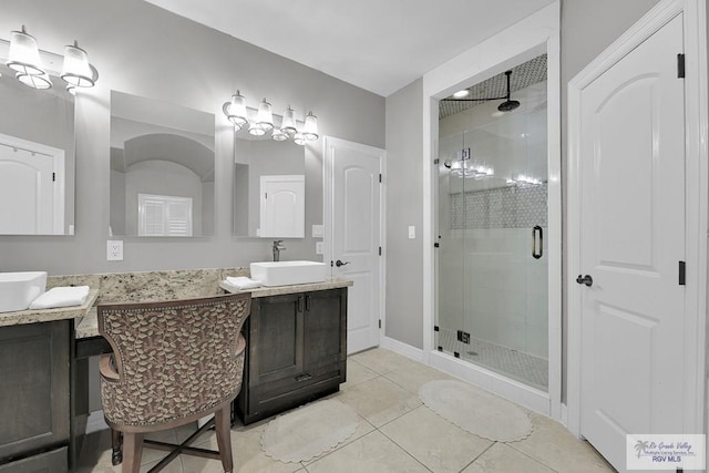 bathroom featuring tile patterned flooring, vanity, and walk in shower