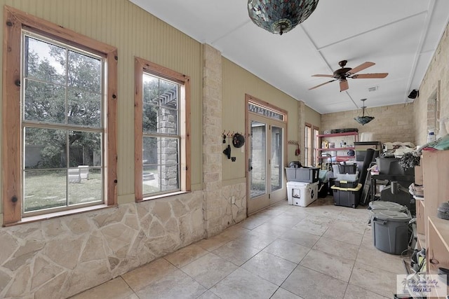 interior space with light tile patterned floors, a wealth of natural light, and ceiling fan