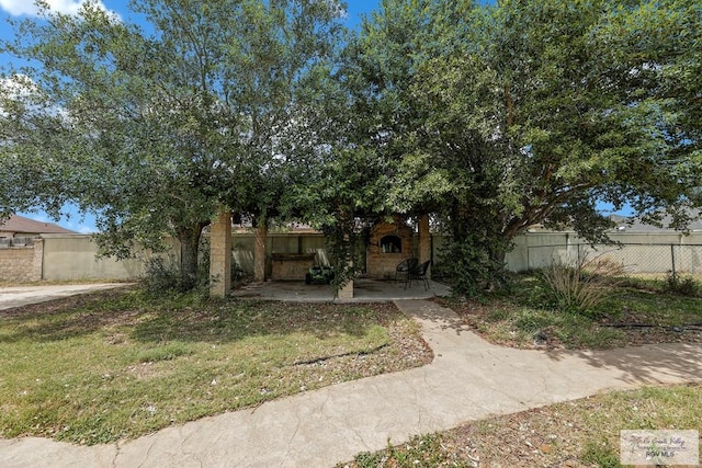 obstructed view of property featuring a front lawn and a patio area