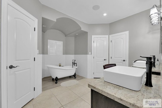 bathroom with tile patterned flooring, sink, and a bath