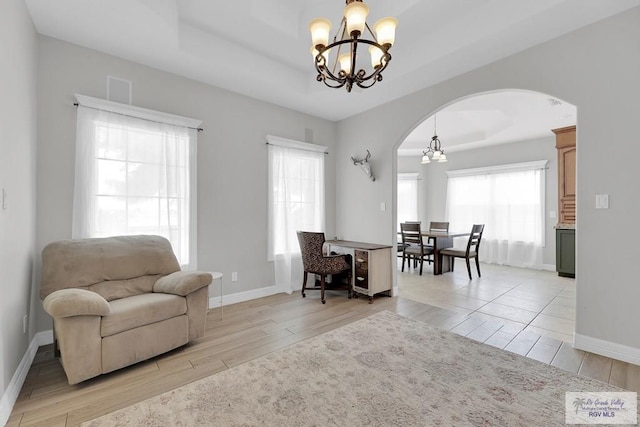 interior space with light hardwood / wood-style flooring, a healthy amount of sunlight, and an inviting chandelier