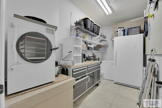 clothes washing area featuring washer / dryer and light tile patterned flooring