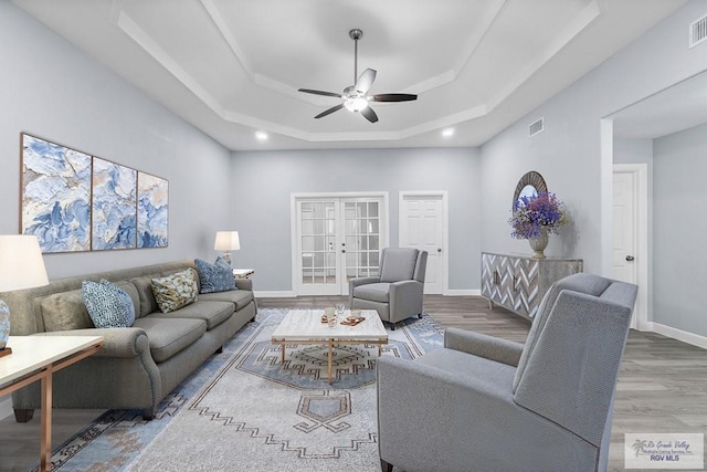 28055 Perk Ln, Harlingen, TX 78552 - living room with a tray ceiling, ceiling fan, wood finished floors, baseboards, and french doors