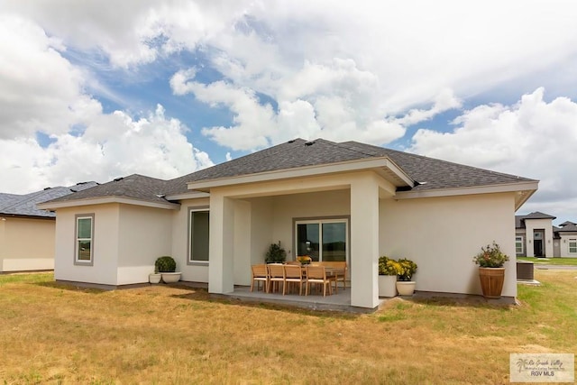 rear view of house featuring a lawn, central air condition unit, and a patio