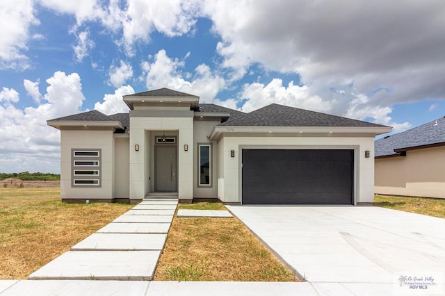 prairie-style home with a front yard and a garage