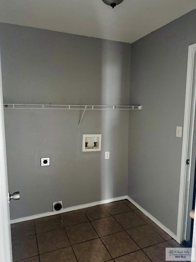 laundry room with electric dryer hookup, dark tile patterned floors, and hookup for a washing machine