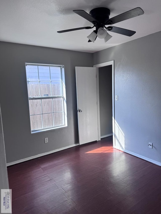 spare room with dark hardwood / wood-style floors and ceiling fan