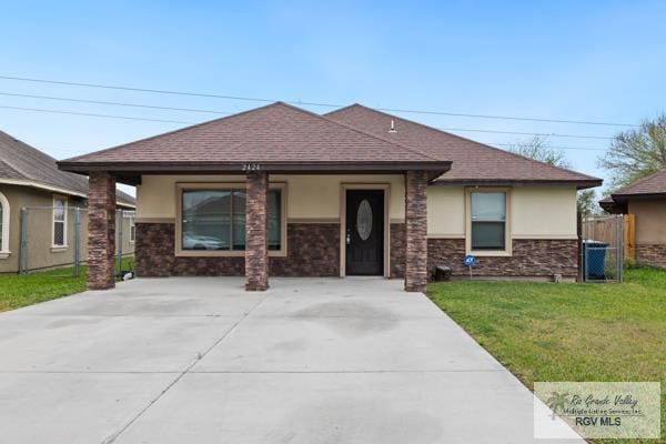 view of front of house featuring a shingled roof, a front yard, fence, and stucco siding