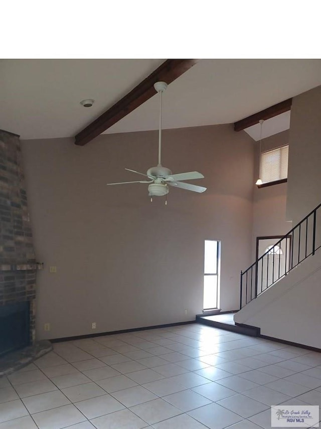 unfurnished living room with a fireplace, ceiling fan, beamed ceiling, and high vaulted ceiling