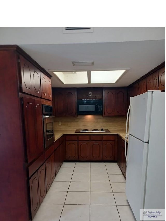 kitchen featuring tasteful backsplash, light tile patterned floors, and stainless steel appliances