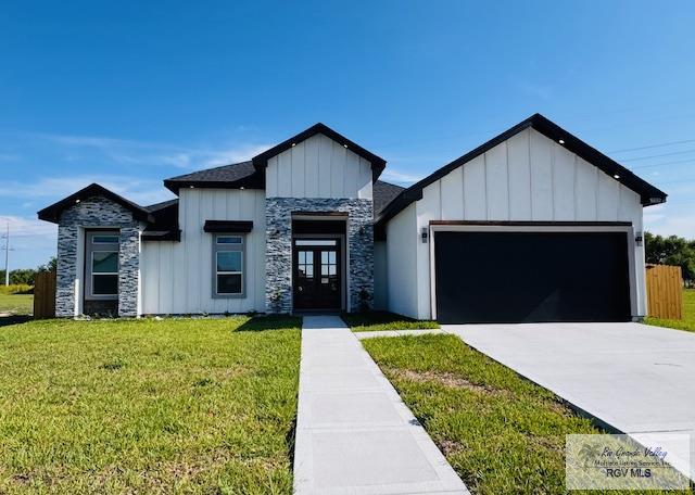 16602 Napper Ln, Primera, TX 78552 - view of front of home featuring french doors, board and batten siding, a garage, and a front lawn