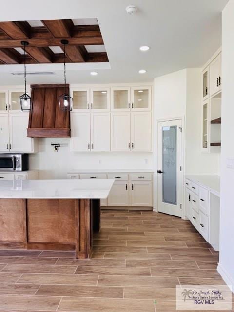 16602 Napper Ln, Primera, TX 78552 - kitchen featuring stainless steel microwave, wood finish floors, glass insert cabinets, recessed lighting, and coffered ceiling