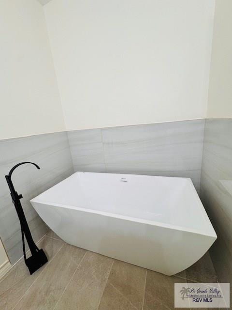 16602 Napper Ln, Primera, TX 78552 - bathroom featuring a soaking tub, tile walls, wainscoting, and tile patterned flooring