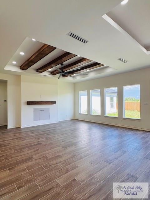 16602 Napper Ln, Primera, TX 78552 - unfurnished living room with wood finished floors, a tray ceiling, baseboards, beamed ceiling, and recessed lighting